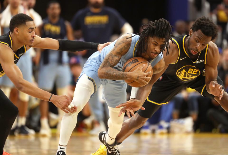 Memphis Grizzlies guard Ja Morant is defended by Golden State Warriors guards Jordan Poole, left, and Andrew Wiggins during Game 3.