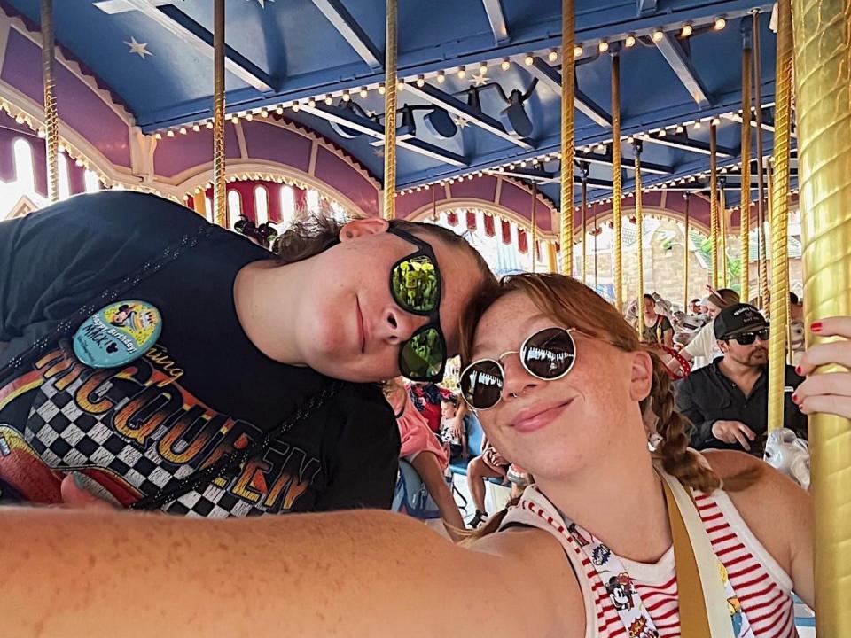 jordyn and her partner posing for a photo on the carosel at disney world