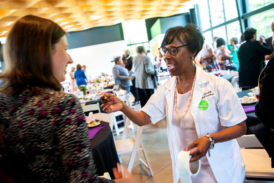 Cynthia Finch hands out “I Got My Shot!” COVID-19 vaccination stickers as guests leave at the conclusion of the 32nd annual Martin Luther King Jr. Commemorative Commission Leadership Awards luncheon at the Knoxville Botanical Gardens and Arboretum on Thursday, June 17, 2021.