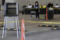 FILE - Election workers attend to voters at a makeshift polling station inside a parking garage in Santa Fe, N.M., on Tuesday, May 5, 2020. The arrangements by Santa Fe County Clerk Geraldine Salazar allow for greater social distancing and air circulation to guard against transmission of the coronavirus and avoids possible contamination of Santa Fe County government offices. Early in-person voting in New Mexico's June 2 primary began as election authorities encourage absentee balloting by mail. (AP Photo/Morgan Lee, File)