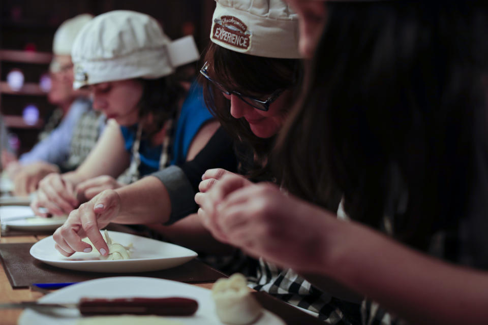 In this March 20, 2017 photo tourist make their own "empanada" during an activity called "The Argentine Experience" in Buenos Aires, Argentina. Tourists participating in "The Argentine Experience" have the chance to learn about the local cuisine, wine and traditions during a dinner in Buenos Aires. (AP Photo/Natacha Pisarenko)