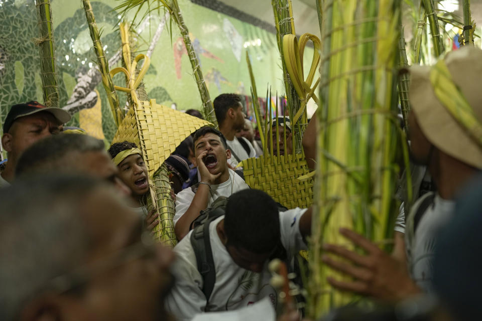 Members of the Palmeros de Chacao brotherhood, chant and sing, as they arrive with palm branches after descending the Cerro el Avila, in Caracas, Venezuela, Saturday, April 1, 2023. Every year the brothers climb the Cerro El Avila to collect the royal palm branches as part of a 250-year tradition that marks the start of Holy Week. The palms will be blessed at the Palm Sunday Mass in the Chacao church. (AP Photo/Matias Delacroix)