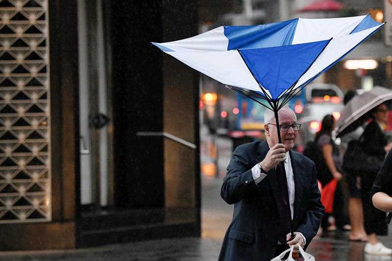 Pedestrians hold umbrellas as they walk in heavy rain in Sydney's CBD.