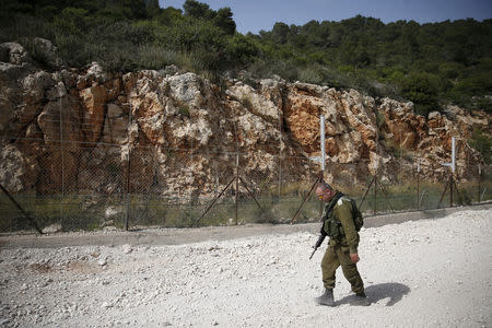 FILE PHOTO: An Israeli soldier walks near the area where the Israeli army is excavating part of a cliff to create an additional barrier along its border with Lebanon, near the community of Shlomi in northern Israel April 6, 2016. REUTERS/Ronen Zvulun/File Photo