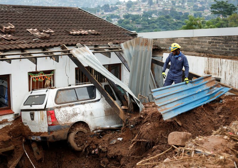 A member of the search and rescue team looks through debris in Dassenhoek near Durban