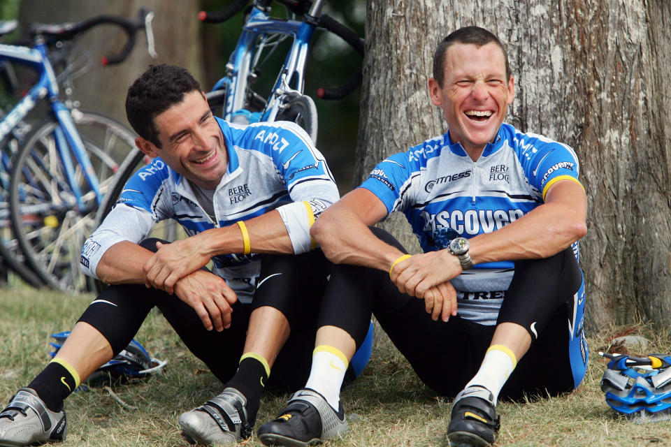 FILE - In this July 18, 2005 file photo, overall leader of the Tour de France cycling race, Lance Armstrong, right, relaxes with compatriot and teammate George Hincapie outside their hotel in Pau, southwestern France. Hincapie was the "Loyal Lieutenant" who helped Armstrong to seven Tour de France titles, only to later provide the key testimony that brought his downfall. Now, Hincapie is peeling back the shroud that has long covered the dark era of doping in cycling in a book due out next month that is part memoir, part mea culpa. (AP Photo/Alessandro Trovati, File)