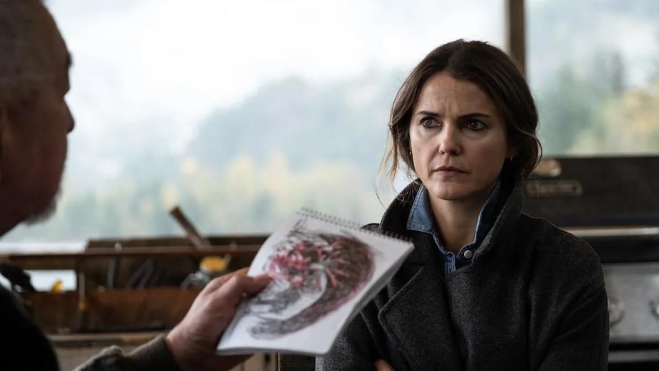 Keri Russell looks concerned as Graham Greene takes a look at a kid's scary drawing of a monster in the creature feature Antlers.