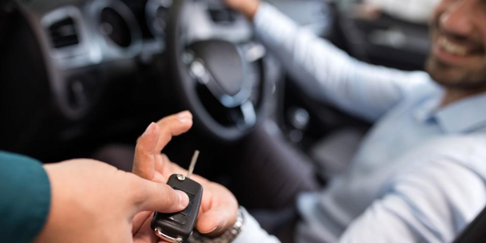 close up of a teenager receiving new car key after getting a car loan