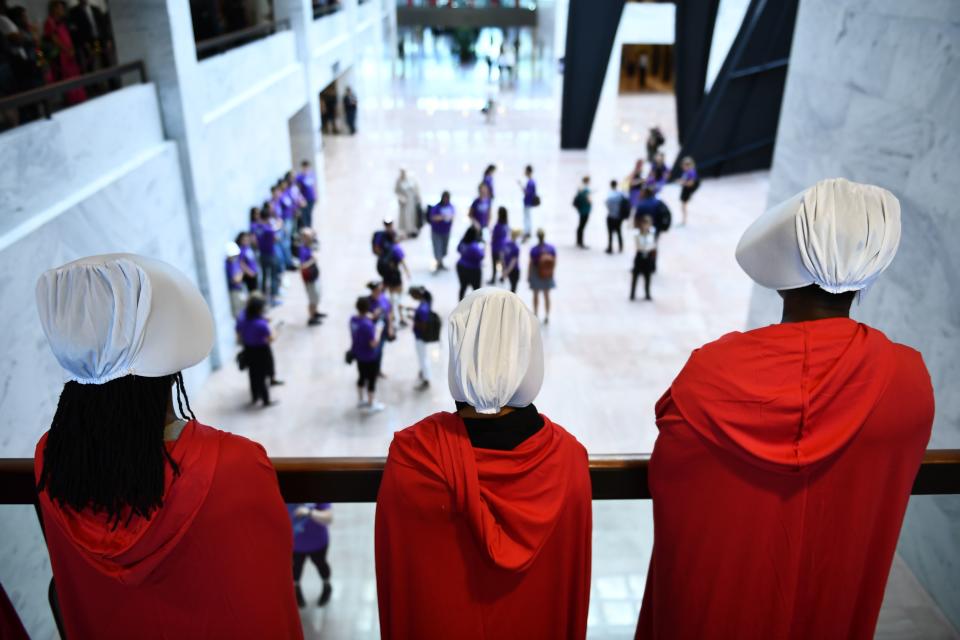 Women dressed as handmaids stood to protest Brett Kavanaugh. (Photo: Brendan Smialowski via Getty Images)