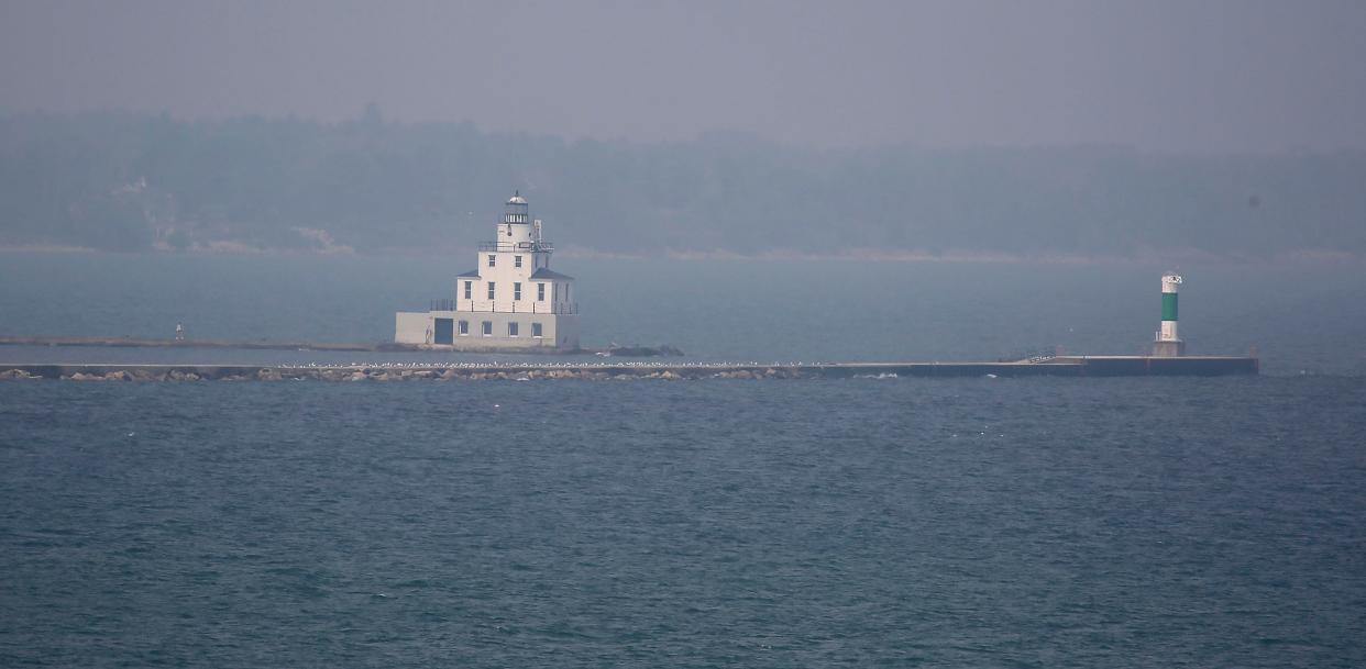 The Manitowoc Breakwater Lighthouse sticks out from the muted grays in the skyline June 28 in Manitowoc.