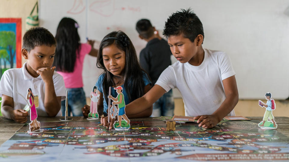 Children in class playing a board game specially developed to teach them the value of the forest, La Chorrera, Colombian Amazon (Luis Barreto, WWF-UK)