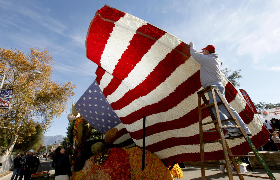 Volunteer David Burney from Milwaukee helps put the finishing touches on the RDF TV rose float in Pasadena Monday, Dec. 31, 2012. (AP Photo/Nick Ut)