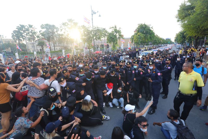 Police scuffle with a group of anti-government demonstrators near the royal motorcade carrying Thailand's Queen Suthida and Prince Dipangkorn in front of the Government House in Bangkok