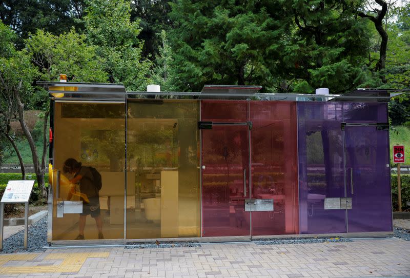 A visitor tries out the transparent public toilet that become opaque when occupied, designed by Japanese architect Shigeru Ban, at Yoyogi Fukamachi Mini Park in Tokyo