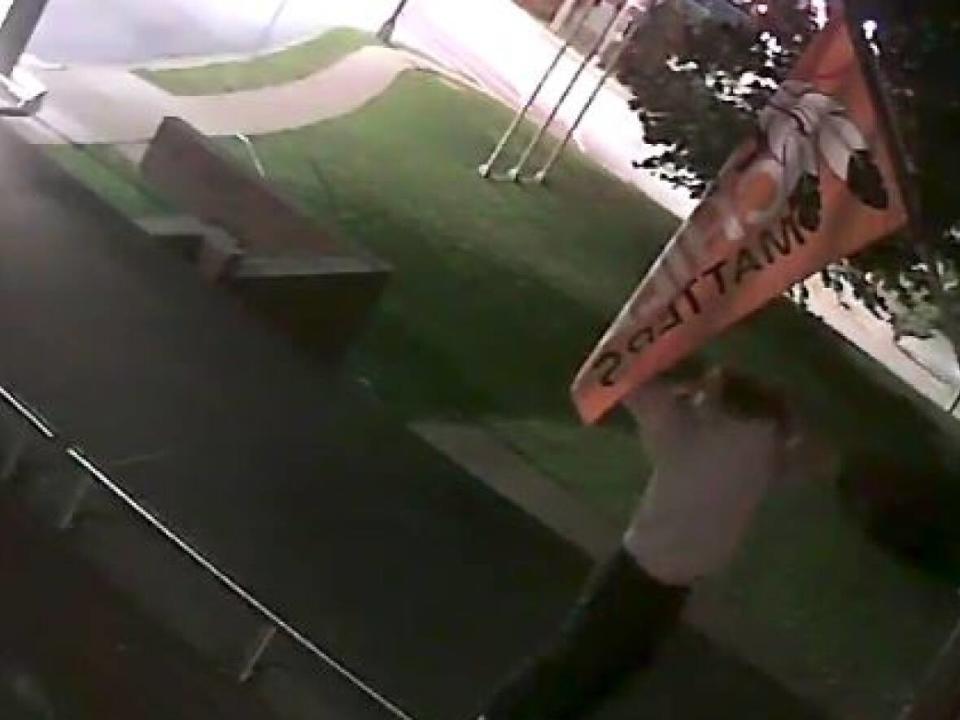 Halifax Regional Police released on Monday this image from video surveillance outside headquarters. Police said it shows a man stealing a Every Child Matters flag on Saturday. (Halifax Regional Police - image credit)