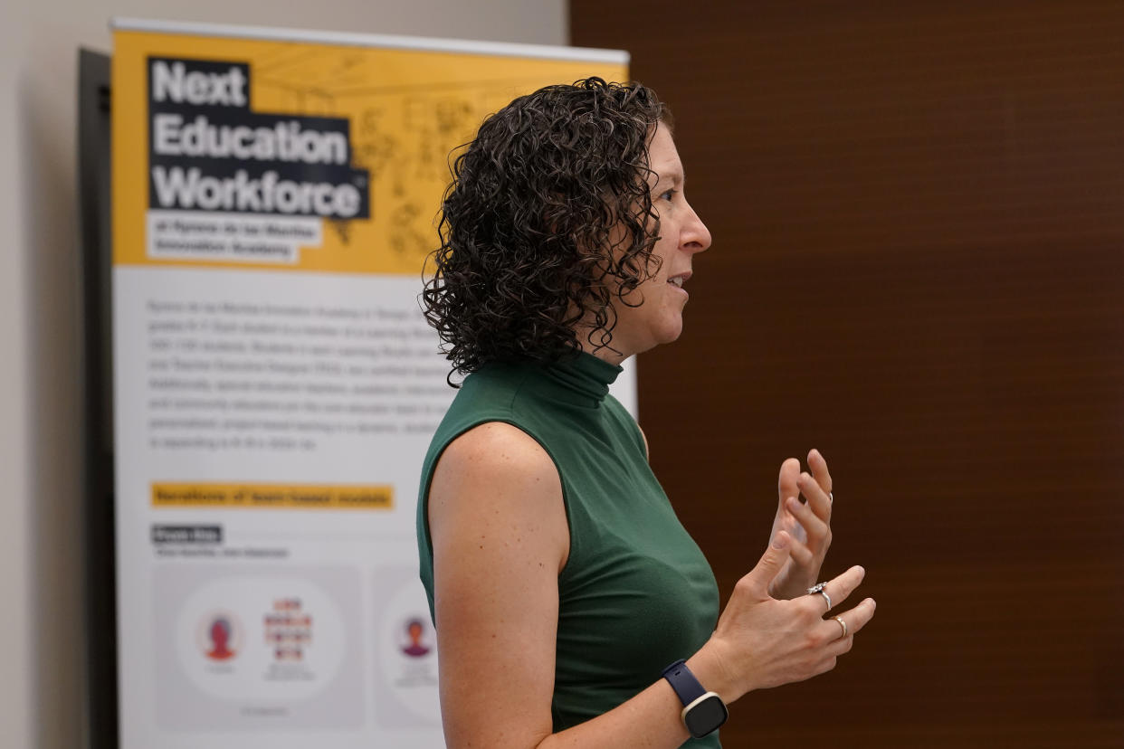 Lisa Wyatt, director of whole-school models for the Next Education Workforce Initiative at Arizona State University, speaks to student ambassadors at Westwood High School, Tuesday, Oct. 18, 2022 in Mesa, Ariz. Like many school districts across the country, Mesa has a teacher shortage due in part due to low morale and declining interest in the profession. Five years ago, Mesa allowed Westwood to pilot a program to make it easier for the district to fill staffing gaps, grant educators greater agency over their work and make teaching a more attractive career. The model, known as team teaching, allows teachers to combine classes and grades rotating between big group instruction, one-on-one interventions, small study groups or whatever the team agrees is a priority each day. (AP Photo/Matt York)