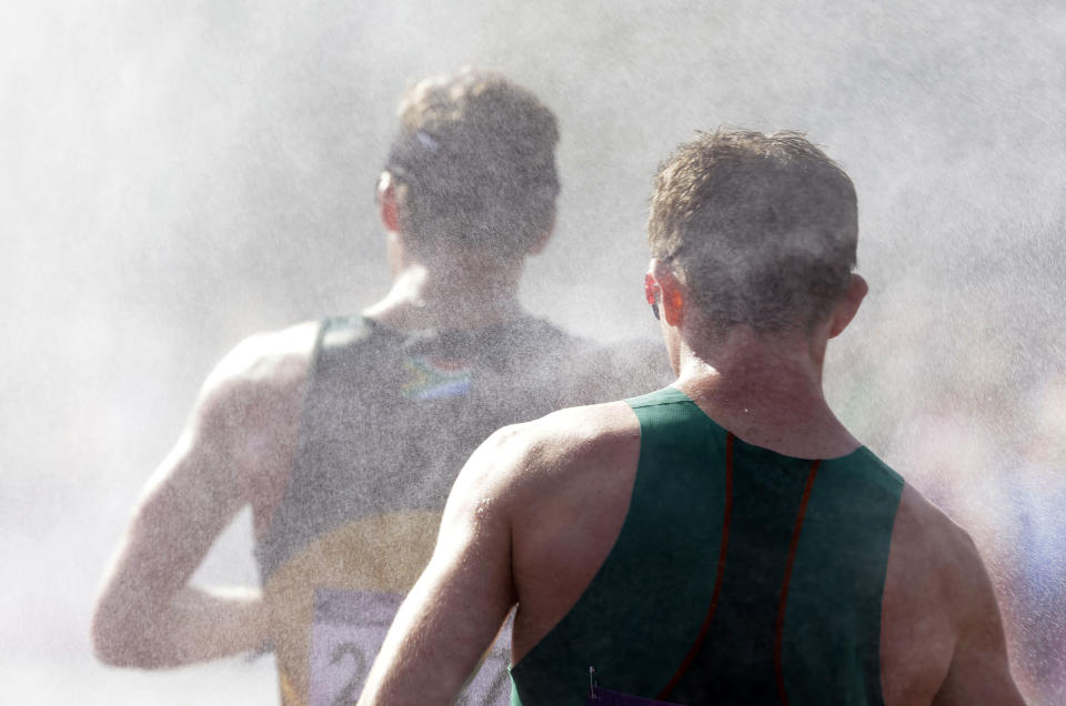 Athletes walk through a mister as they compete in the men's 50-kilometer race walk, at the 2012 Summer Olympics, Saturday, Aug. 11, 2012, in London. (AP Photo/Lefteris Pitarakis)