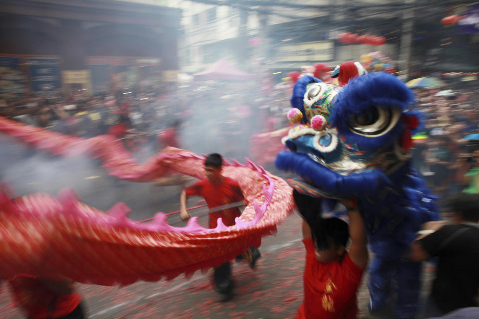 Dragon and lion dancers perform amidst exploding firecrackers in front of a business establishment in celebration of the Chinese Lunar New Year, Saturday, Jan. 28, 2017, in the Chinatown area of Manila, Philippines. This year is the Year of the Rooster on the Chinese lunar calendar. (AP Photo/Bullit Marquez)