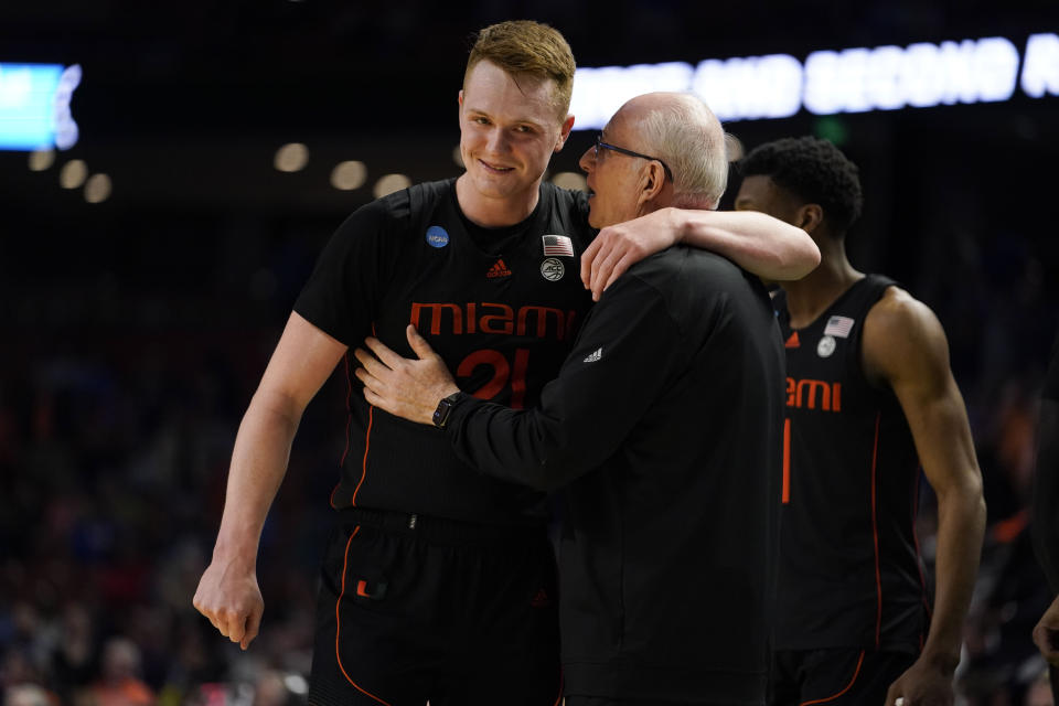 Miami head coach Jim Larranaga, front right, talks to Sam Waardenburg (21) after a win over Auburn in a college basketball game in the second round of the NCAA tournament, Sunday, March 20, 2022, in Greenville, S.C. (AP Photo/Brynn Anderson)