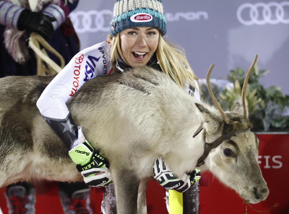 United States's Mikaela Shiffrin makes friends with a cub of reindeer she was awarded after winning an alpine ski, women's World Cup slalom, in Levi, Finland, Saturday, Nov. 17, 2018. (AP Photo/Gabriele Facciotti)