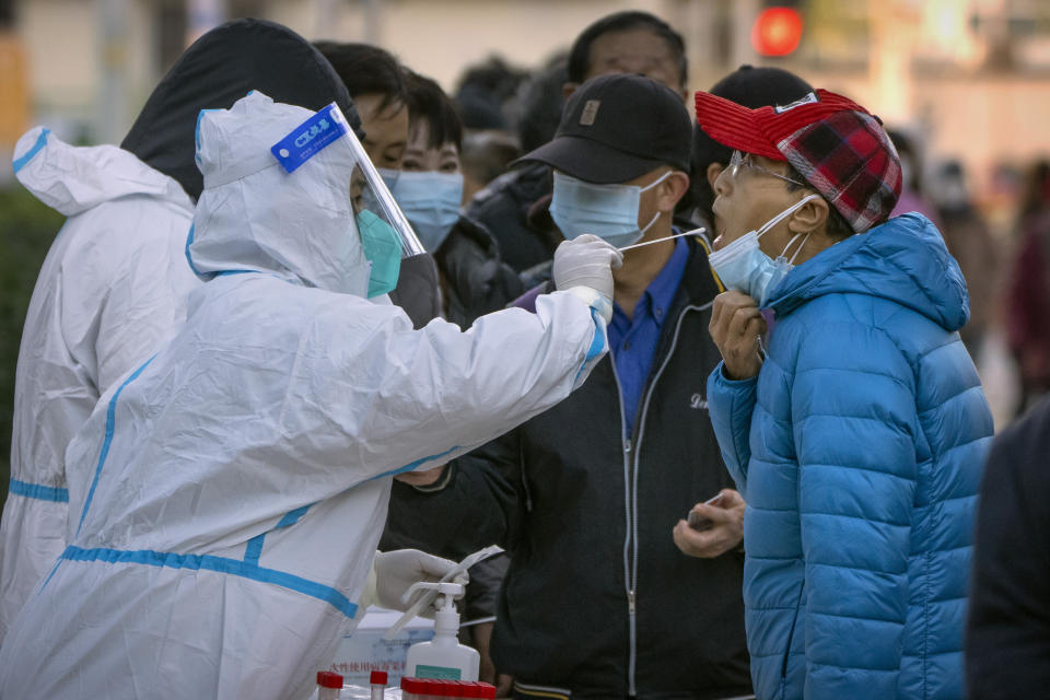 A man has his throat swabbed for a COVID-19 test at a coronavirus testing site in Beijing, Tuesday, Nov. 15, 2022. The flagship newspaper of China's ruling Communist Party has called for strict adherence to the country's hardline "zero-COVID" policy, in an apparent attempt to guide public perceptions following a slight loosening of anti-virus regulations. (AP Photo/Mark Schiefelbein)