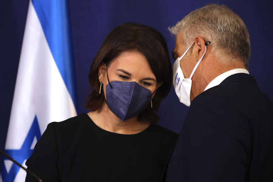 German Foreign Minister Annalena Baerbock and Israeli Foreign Minister Yair Lapid talk after a joint press conference in Tel Aviv, Israel, Thursday, Feb. 10, 2022. (AP Photo/Oren Ziv)