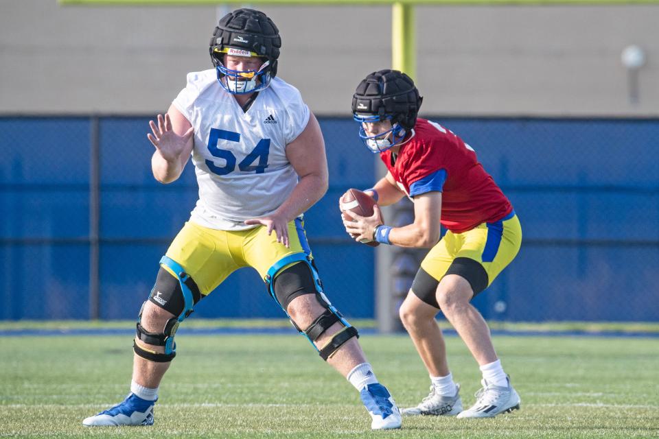 Delaware Blue Hens offensive lineman Fintan Brose (54) blocks while quarterback Zach Marker (3) prepares for a pass during the first preseason football practice at the University of Delaware football practice field in Newark, Monday, July 31, 2023.