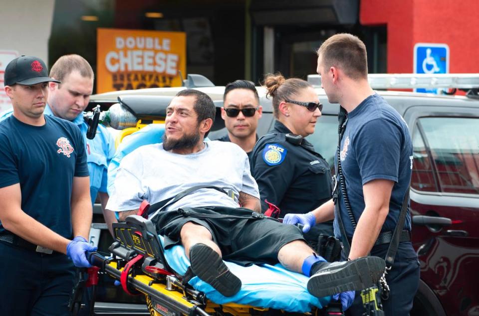 The carjacking suspect is taken on a stretcher to an ambulance in the parking lot of the Del Taco on Alhambra Boulevard on Friday. Nathaniel Levine/nlevine@sacbee.com