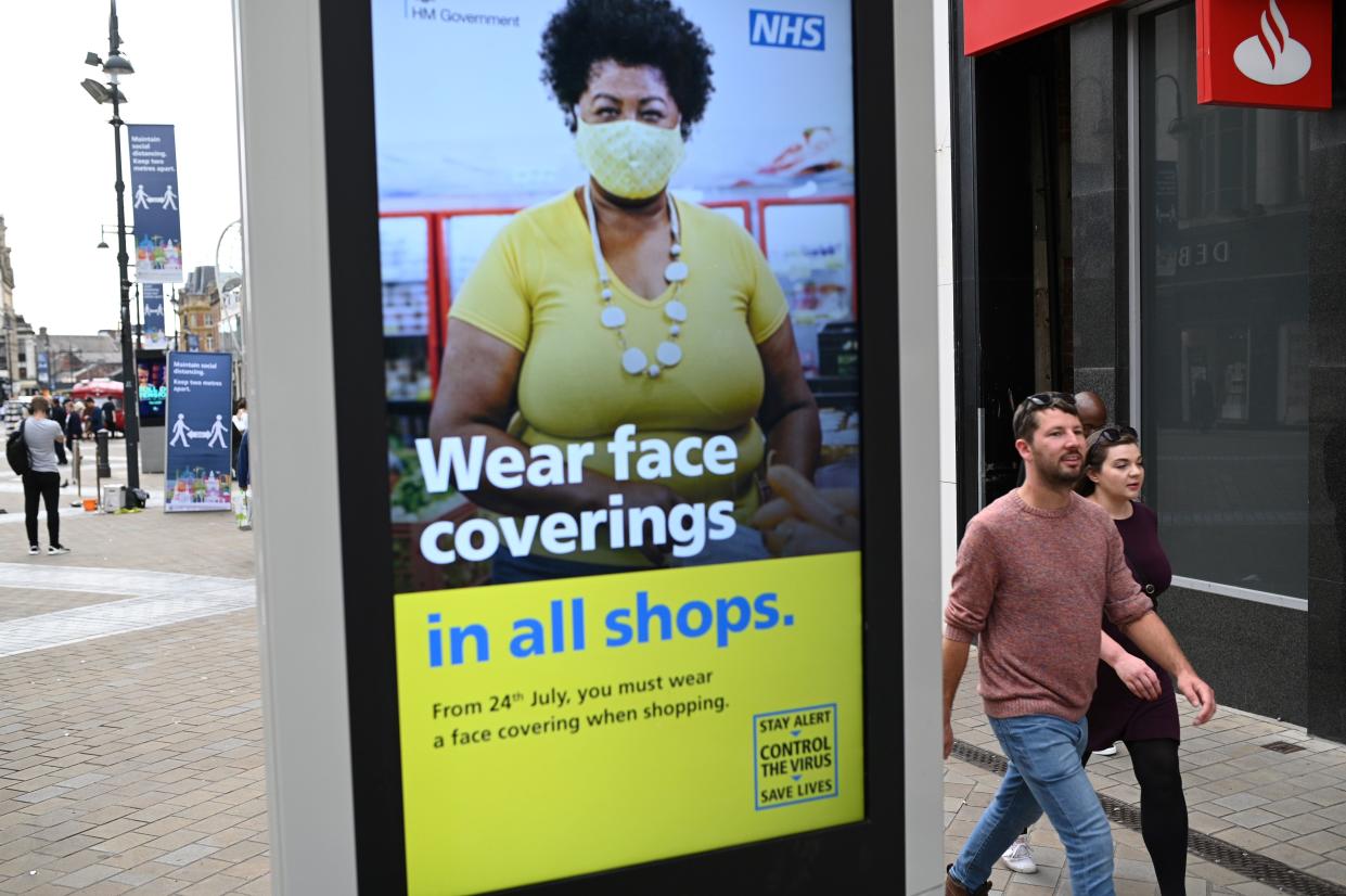 A sign calling for the wearing of face coverings in shops is displayed  in the city centre of Leeds, on July 23, 2020, as lockdown restrictions continue to be eased during the novel coronavirus COVID-19 pandemic. - The wearing of facemasks in shops in England will be compulsory from Friday, but full guidance is yet to be published. (Photo by Oli SCARFF / AFP) (Photo by OLI SCARFF/AFP via Getty Images)