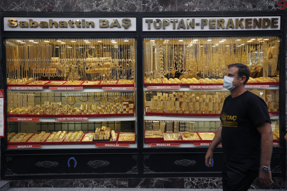 A man walks past a gold shop in Istanbul, Friday, Aug. 7, 2020. Turkey's currency tumbled further Friday, hitting another record low. The Turkish lira dropped to 7.3677 against the dollar before making a recovery. The lira is down about 19% versus the U.S. currency since the beginning of the year. (AP Photo/Emrah Gurel)