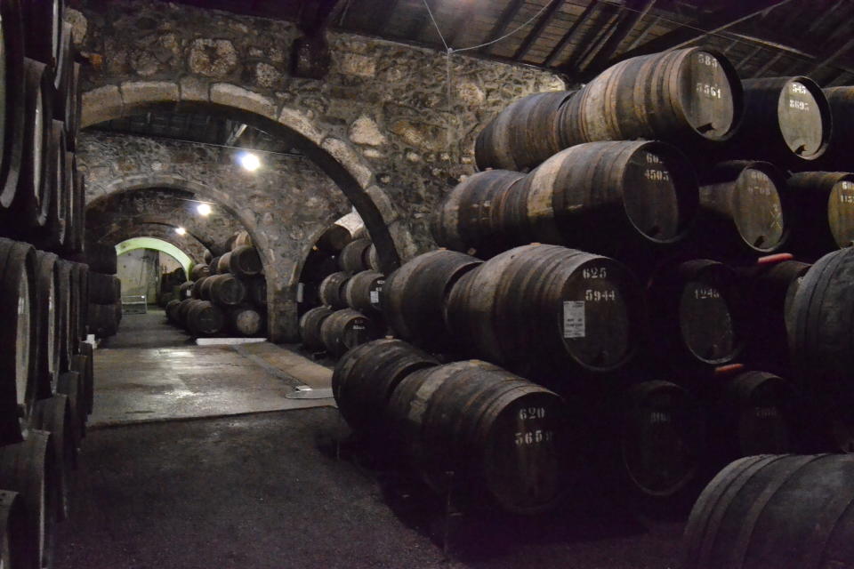 This Feb. 21, 2017 photo shows the warehouse at the Croft port wine house in Vila Nova de Gaia, Portugal. The stone building, which is dug into the side of a hill, keeps hundreds of wine barrels that age for up to 40 years. (Albert Stumm via AP)