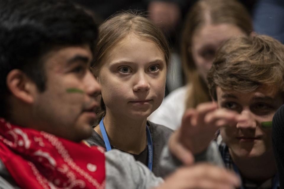 Climate activist Greta Thunberg, center, talks with other climate activists youth at the COP25 climate talks summit in Madrid, Friday Dec. 6, 2019. Thunberg arrived in Madrid Friday to join thousands of other young people in a march to demand world leaders take real action against climate change. (AP Photo/Bernat Armangue)