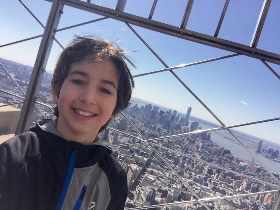 Nate Bronstein poses atop the Empire State Building in New York