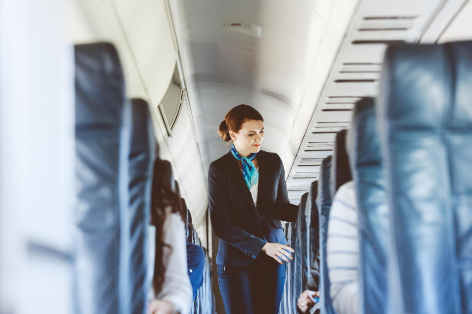 Beautiful air stewardess inside an airplane.