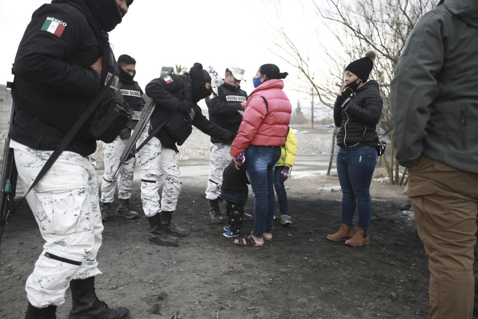 A Cuban migrant family is apprehended by the National Guard before crossing the Rio Bravo on the border with the U.S. in Ciudad Juarez, Chihuahua state, Mexico, Tuesday, Feb. 16, 2021. The number of people apprehended at the U.S.-Mexico border has increased since Jan. with migrant families crossing from Ciudad Juarez and turning themselves over to Border Patrol. (AP Photo/Christian Chavez)