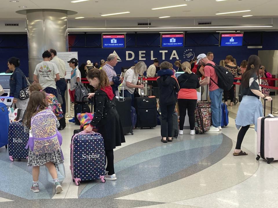 Delta Airline passengers line up in Terminal 2 in anticipation of operations resuming at Fort Lauderdale-Hollywood International Airport on Friday, April 14, 2023. The airport was closed late Wednesday after torrential rains caused major flooding across South Florida. (Mike Stocker/South Florida Sun-Sentinel via AP)