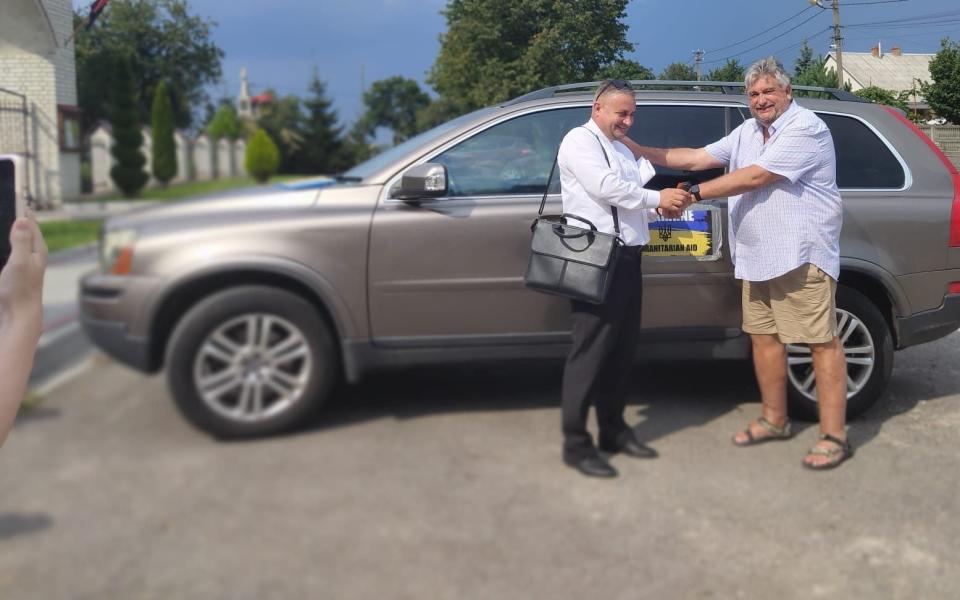 Ukrainian charity representatives receive Charles Cooper's car in August 2023