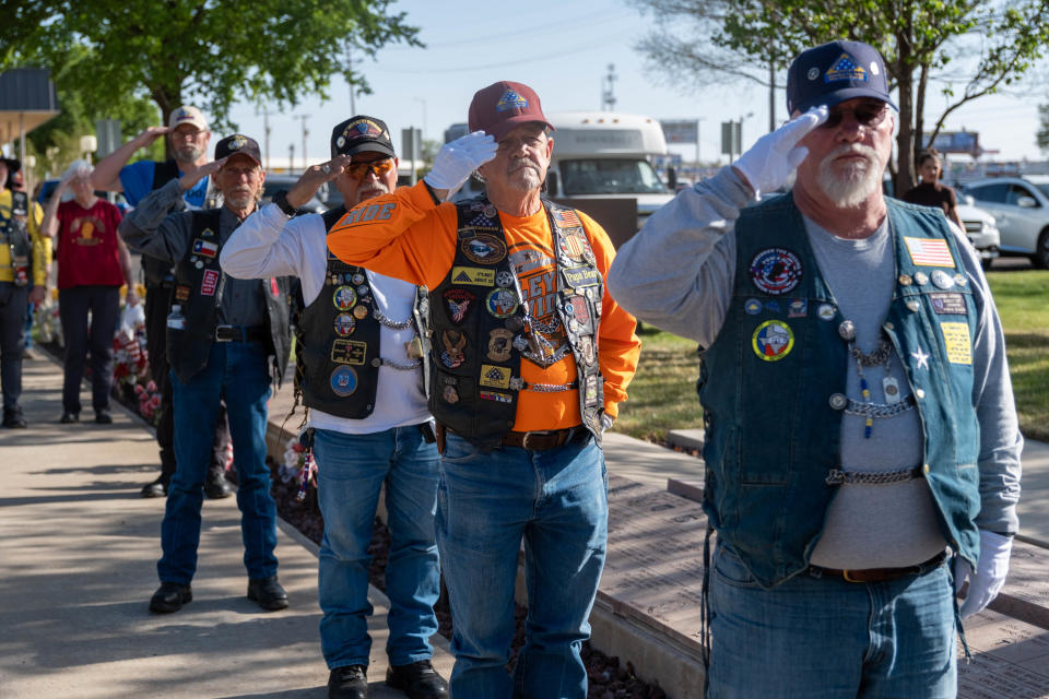 Veterans stand and salute Wednesday evening during the Missing in America's Project ceremony honoring three unclaimed veterans at the Texas Panhandle War Memorial Center in Amarillo.