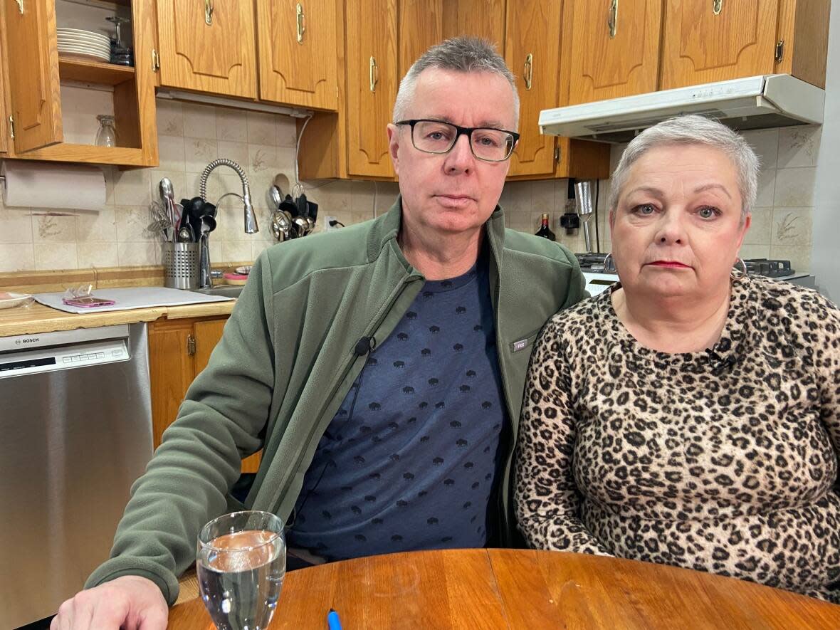 Tony and Ann Marie Norman sit in their kitchen, where new glossy white cabinets should be. They ordered new cabinets from Ikea in February 2022 but still don't have all the items they need — and the company no longer ships large orders to Newfoundland and Labrador. (Heather Gillis/CBC - image credit)