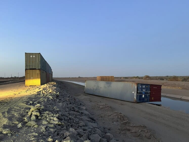 Esta foto proporcionada por Univision Arizona muestra contenedores de carga vacíos derribados el domingo por la noche en la frontera internacional entre México y Estados Unidos en Yuma, Arizona, el lunes 16 de agosto de 2022. (Claudia Ramos/Univision Arizona vía AP)