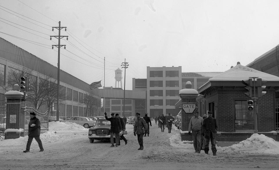 Studebaker employees emerge through Gate 1 on Sample Street at 3:30 p.m. Monday, Dec. 9, 1963, at the end of their shift shortly after company officials in New York City confirmed news stories that automotive production in South Bend would be shifted to the corporation's Hamilton, Ont., plant in Canada. Newsmen were waiting at plant gates to interview workers. The company had refused newsmen permission to enter the plant for photos and interviews. The last car is produced in South Bend on Dec. 20. The American flag, upper left, flies in mourning for President John F. Kennedy.