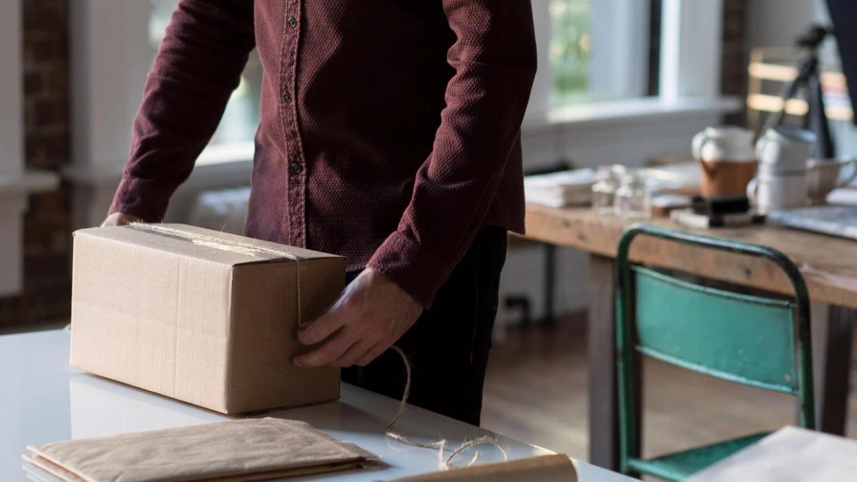  A person lifting a packing box. 