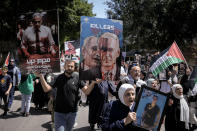 Palestinians hold photographs of prisoners jailed in Israel and posters depicting Israeli Prime Minister Benjamin Netanyahu and U.S. President Joe Biden, during a rally marking the annual prisoners' day in the West Bank city of Nablus, Wednesday, April 17, 2024. (AP Photo/Majdi Mohammed)