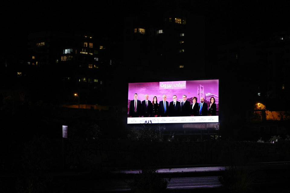 An electoral banner for candidates in the upcoming parliamentary elections glows during power cut in Beirut, Lebanon, Monday, May 9, 2022. Given Lebanon's devastating economic meltdown, Sunday's parliament election is seen as an opportunity to punish the current crop of politicians that have driven the country to the ground. Yet a sense of widespread apathy and cynicism prevails, with many saying it is futile to expect change. (AP Photo/Hassan Ammar)