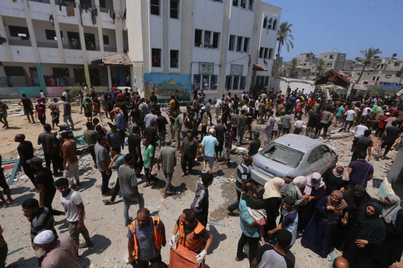 Palestinians flee a school where they sought refuge after it was hit by an Israeli attack in Deir el-Balah in the central Gaza Strip. Omar Ashtawy/APA Images via ZUMA Press Wire/dpa