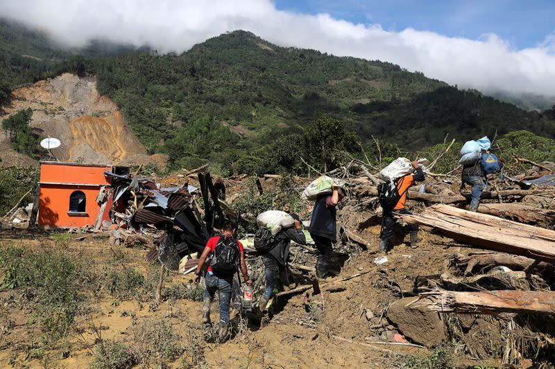 FILE PHOTO: Residents carry their belongings recovered from their houses damaged by a mudslide, caused by heavy rains brought by Storm Eta, as the search for victims continue in the buried village of Queja