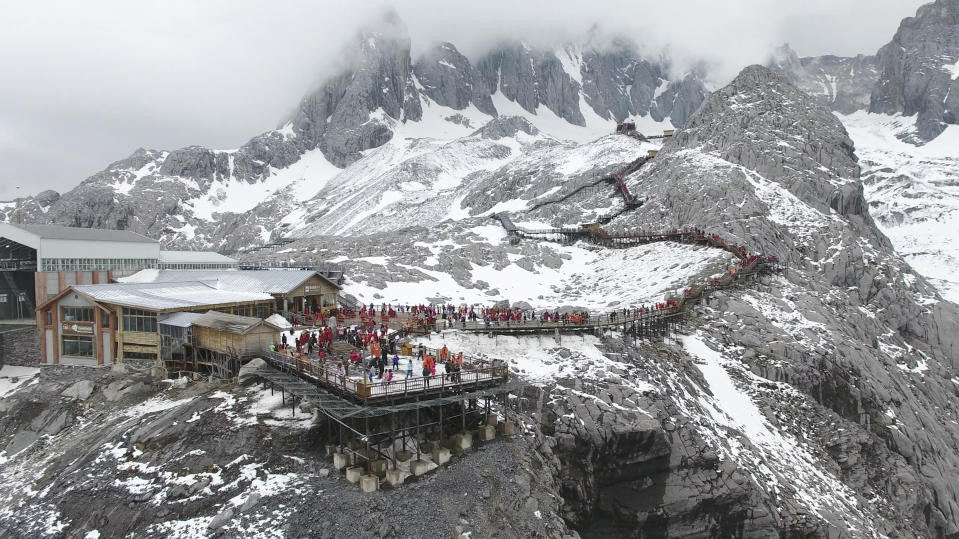 In this photo taken May 2018, and released by Yulong Snow Mountain Glacier and Environmental Observation Research Station on Oct. 18, 2018, tourists gather on a platform above the Baishui Glacier No.1 on the Jade Dragon Snow Mountain in the southern province of Yunnan in China. Scientists say the glacier is one of the fastest melting glaciers in the world due to climate change and its relative proximity to the Equator. It has lost 60 percent of its mass and shrunk 250 meters since 1982. (Yulong Snow Mountain Glacier and Environmental Observation Research Station via AP)