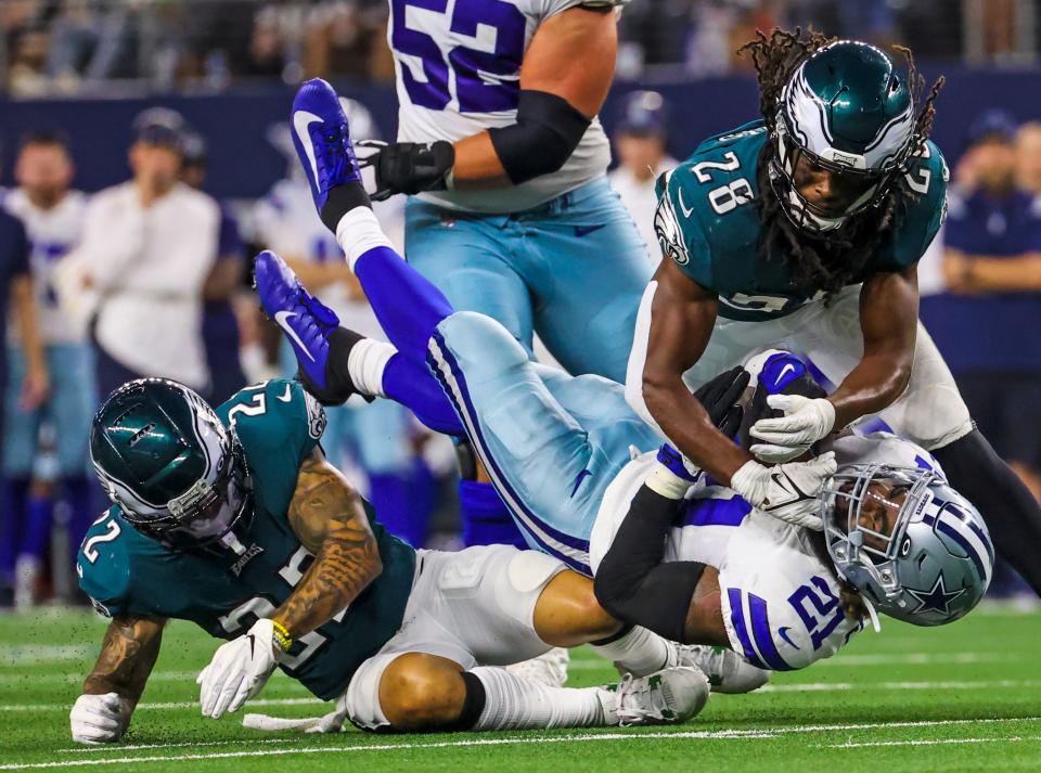 Sep 27, 2021; Arlington, Texas, USA;  Philadelphia Eagles defensive back Anthony Harris (28) tackles Dallas Cowboys running back Ezekiel Elliott (21) during the game at AT&T Stadium.