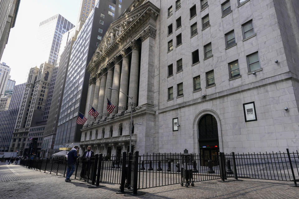 FILE - A trader, right, talks to a pedestrian outside the New York Stock exchange, Jan. 14, 2022, in the Financial District. Stocks are off to a mixed start on Wall Street Monday, March 28, 2022 as gains for some big technology companies are offset by weakness in energy stocks as crude oil prices fall sharply. The S&P 500 was moving between small gains and losses in the early going. The Dow Jones Industrial Average was off 0.4% and the tech-heavy Nasdaq added 0.8%. (AP Photo/Mary Altaffer, file)