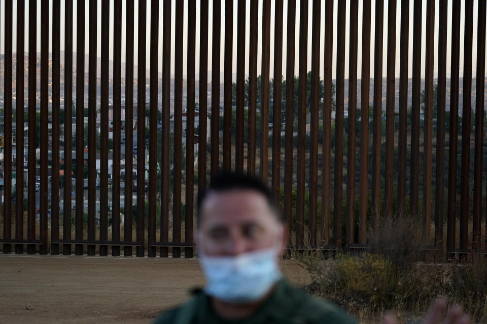 Border Patrol agent Justin Castrejon speaks in front of newly replaced border wall sections Thursday, Sept. 24, 2020, near Tecate, Calif. Top Trump administration officials will visit South Texas five days before Election Day to announce they have completed 400 miles of U.S.-Mexico border wall, attempting to show progress on perhaps the president's best-known campaign promise four years ago. But most of the wall went up in areas that already had smaller barriers. (AP Photo/Gregory Bull)